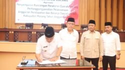 Bupati Malang HM Sanusi saat menandatangani dokumen resmi dalam Rapat Paripurna DPRD Kabupaten Malang yang membahas pertanggungjawaban APBD Tahun 2025.
